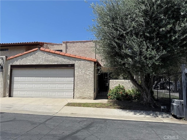 9025 Willis Ave Unit 141, Panorama City, CA 91402 - view of front of house with an attached garage, concrete driveway, stucco siding, and a tiled roof