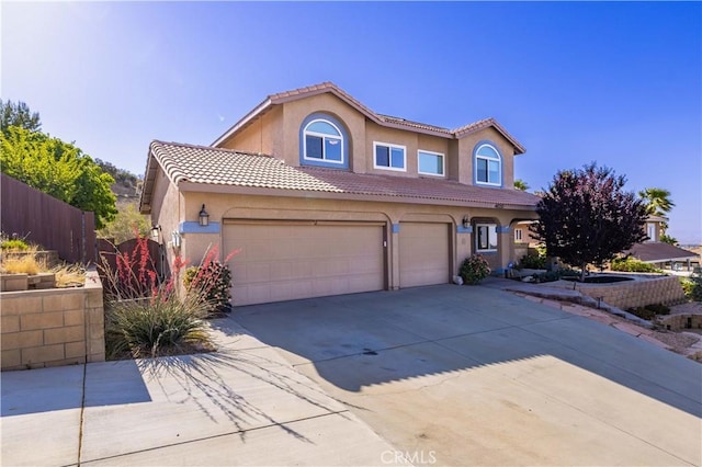 view of front of home with stucco siding, concrete driveway, a tile roof, and an attached garage