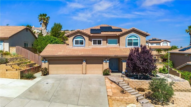 mediterranean / spanish-style home featuring stucco siding, driveway, solar panels, a garage, and a tile roof