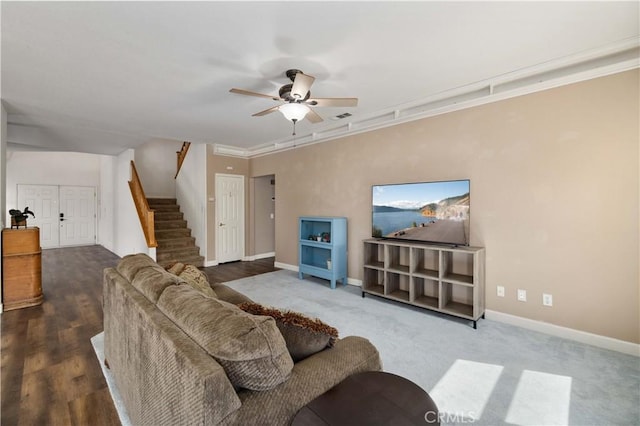 living area with a ceiling fan, stairs, and baseboards