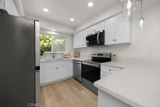1881 Mitchell Ave Unit 114, Tustin, CA 92780 - kitchen with stainless steel appliances, a sink, light wood-style floors, white cabinetry, and recessed lighting