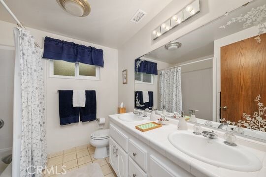 6741 Monero Dr, Rancho Palos Verdes, CA 90275 - full bathroom with double vanity, tile patterned floors, toilet, and curtained shower