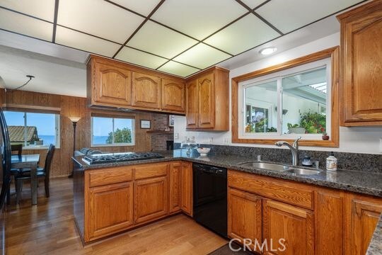 6741 Monero Dr, Rancho Palos Verdes, CA 90275 - kitchen with black dishwasher, brown cabinetry, a sink, and cooktop
