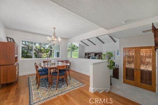 6741 Monero Dr, Rancho Palos Verdes, CA 90275 - dining area featuring wood finished floors, a chandelier, baseboards, and a textured ceiling