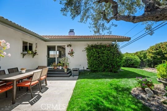 6741 Monero Dr, Rancho Palos Verdes, CA 90275 - doorway to property featuring a chimney, a lawn, stucco siding, a patio area, and outdoor dining area