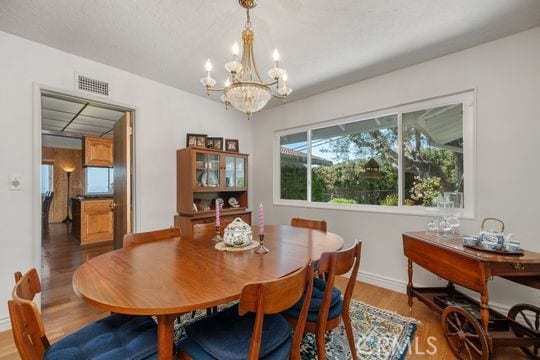 6741 Monero Dr, Rancho Palos Verdes, CA 90275 - dining area featuring a chandelier, wood finished floors, and baseboards