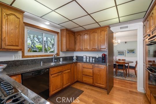 6741 Monero Dr, Rancho Palos Verdes, CA 90275 - kitchen with dishwasher, a sink, light wood finished floors, and brown cabinetry