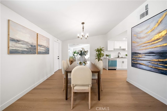 12391 Beck Ave, Garden Grove, CA 92840 - dining space featuring a chandelier, light wood-style floors, baseboards, and lofted ceiling