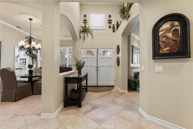 1444 Upland Hills Dr N, Upland, CA 91784 - foyer entrance with arched walkways, crown molding, baseboards, tile patterned floors, and a chandelier