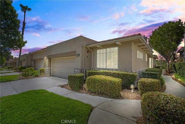 1444 Upland Hills Dr N, Upland, CA 91784 - view of front facade with a garage, driveway, stucco siding, and stone siding