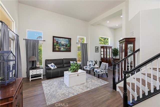 42276 Camino Merano, Temecula, CA 92592 - living area with healthy amount of natural light, dark wood-style flooring, a towering ceiling, stairs, and recessed lighting