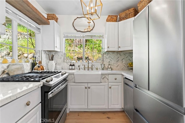 29613 Hook Creek Rd, Cedar Glen, CA 92321 - kitchen featuring stainless steel appliances, a chandelier, a sink, white cabinets, and plenty of natural light