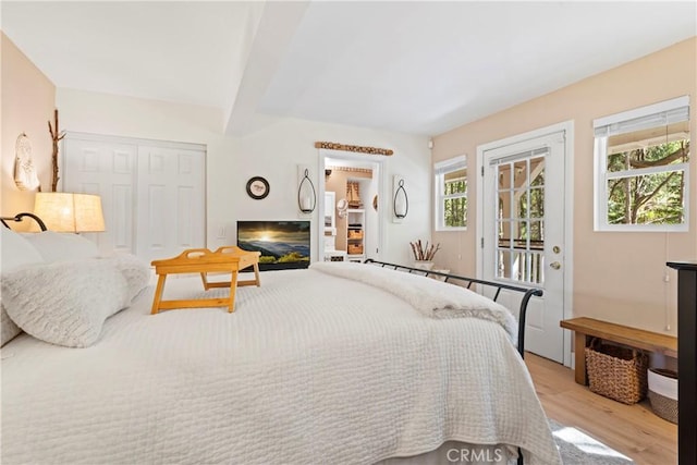 29613 Hook Creek Rd, Cedar Glen, CA 92321 - bedroom with light wood-style flooring, access to outside, a closet, beamed ceiling, and a glass covered fireplace