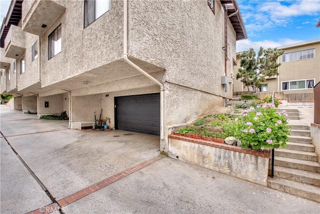 235 S Chandler Ave Unit D, Monterey Park, CA 91754 - view of property exterior with an attached garage, stucco siding, and concrete driveway