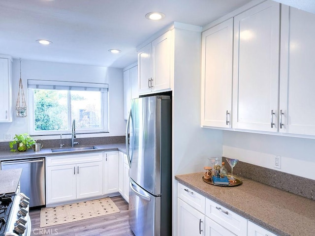 1927 W 84th Pl, Los Angeles, CA 90047 - kitchen with stainless steel appliances, a sink, white cabinetry, light wood-style floors, and recessed lighting