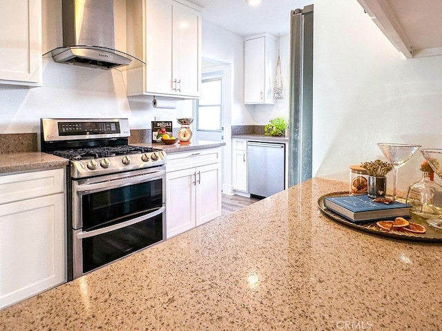 1927 W 84th Pl, Los Angeles, CA 90047 - kitchen featuring wall chimney range hood, stainless steel appliances, white cabinetry, and light stone countertops