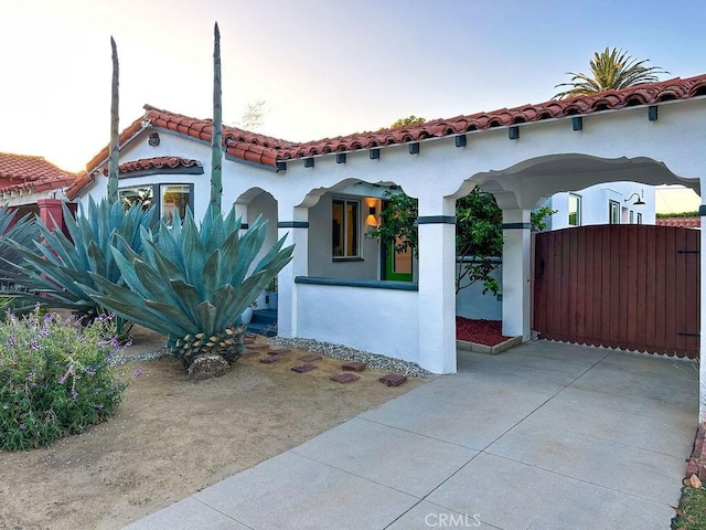 1927 W 84th Pl, Los Angeles, CA 90047 - mediterranean / spanish home featuring stucco siding, a tile roof, and a gate