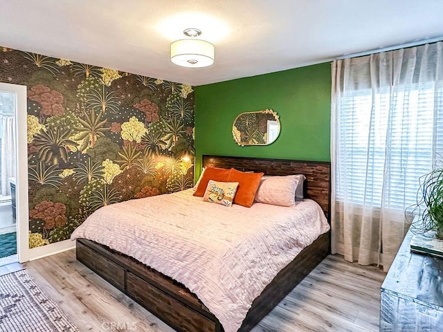 1927 W 84th Pl, Los Angeles, CA 90047 - bedroom with multiple windows, wallpapered walls, wood finished floors, and an accent wall