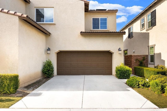 16075 Osprey Ave, Chino, CA 91708 - view of front facade featuring a garage, stucco siding, driveway, and a tile roof