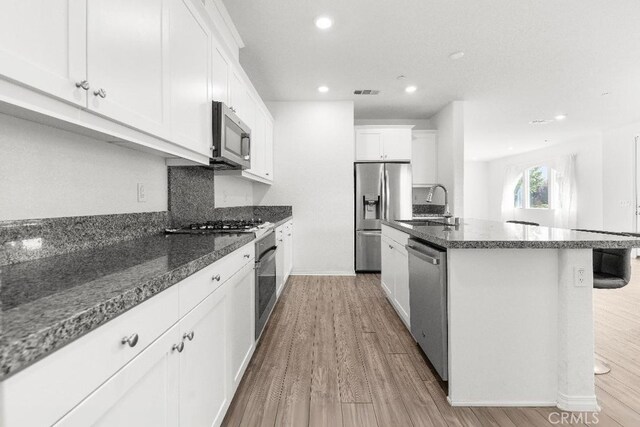16075 Osprey Ave, Chino, CA 91708 - kitchen featuring appliances with stainless steel finishes, a sink, light wood-style flooring, a center island with sink, and recessed lighting