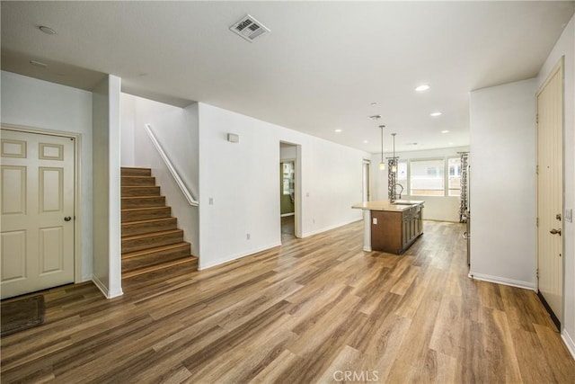 1438 Madrid Dr, Pomona, CA 91766 - unfurnished living room featuring wood finished floors, stairway, a sink, baseboards, and recessed lighting