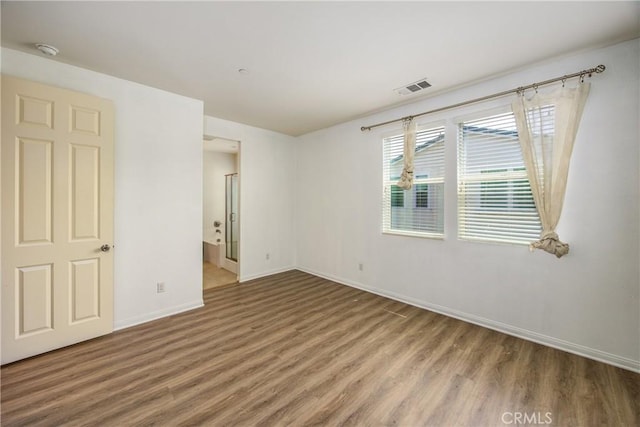 1438 Madrid Dr, Pomona, CA 91766 - unfurnished bedroom featuring wood finished floors, baseboards, and ensuite bathroom