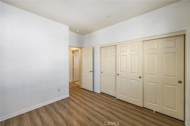 1438 Madrid Dr, Pomona, CA 91766 - unfurnished bedroom with wood finished floors, baseboards, and a closet