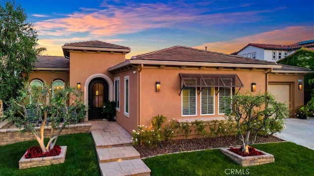 6888 Copper Creek Pl, Moorpark, CA 93021 - mediterranean / spanish house featuring an attached garage, driveway, stucco siding, and a yard