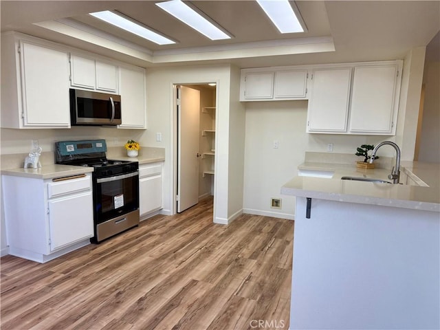 15620 Smoke Tree St, Hesperia, CA 92345 - kitchen featuring appliances with stainless steel finishes, white cabinets, light wood-style flooring, and light countertops
