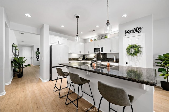 27286 Wedgewood Way, Murrieta, CA 92562 - kitchen with white appliances, a sink, light wood finished floors, white cabinets, and decorative light fixtures