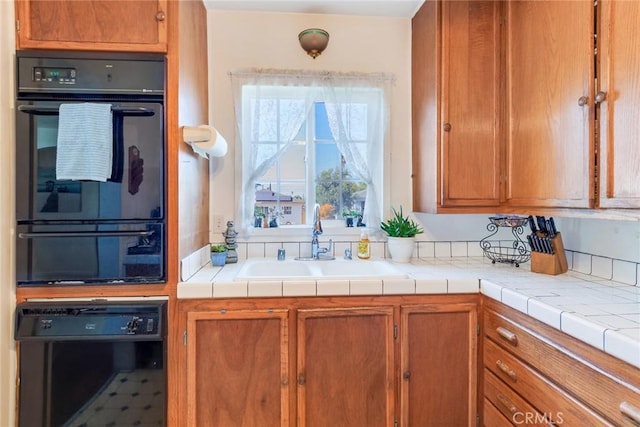 946 W 9th St, Corona, CA 92882 - kitchen with a sink, brown cabinetry, black appliances, and light countertops
