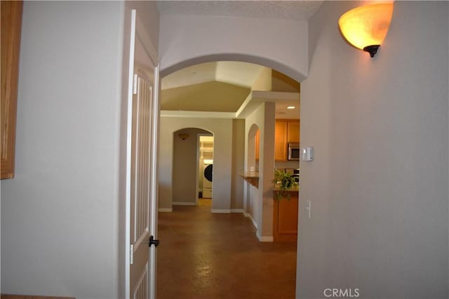 8065 Oxford Ave, Hesperia, CA 92345 - hall featuring finished concrete floors, arched walkways, washer / clothes dryer, and baseboards