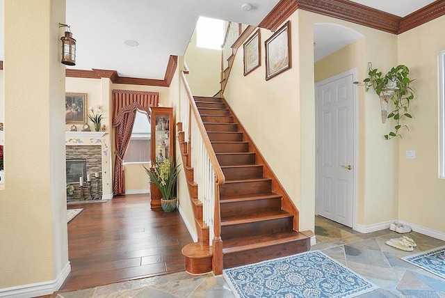 7132 Torrey Mesa Ct, San Diego, CA 92129 - staircase with arched walkways, baseboards, crown molding, a glass covered fireplace, and stone finish flooring