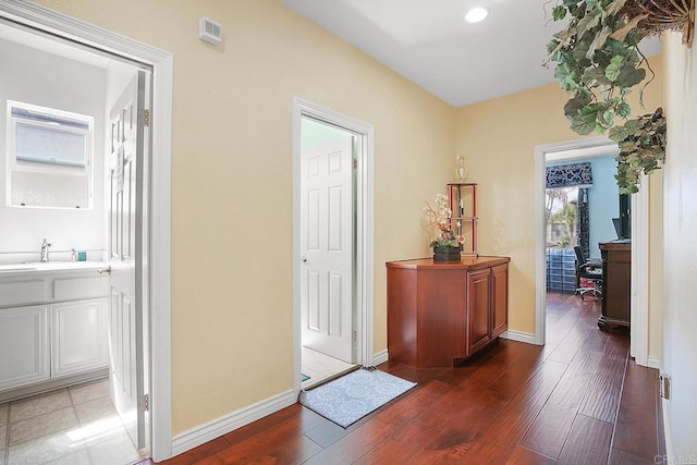 7132 Torrey Mesa Ct, San Diego, CA 92129 - hall with dark wood-type flooring, a sink, baseboards, and recessed lighting