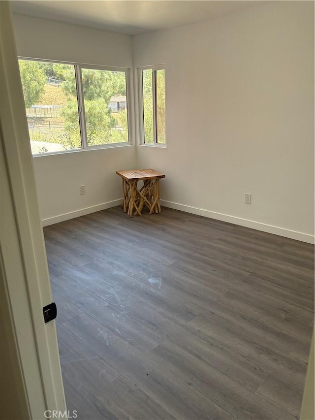 22555 Fern Ann Falls Rd, Chatsworth, CA 91311 - unfurnished room with plenty of natural light, baseboards, and dark wood-type flooring