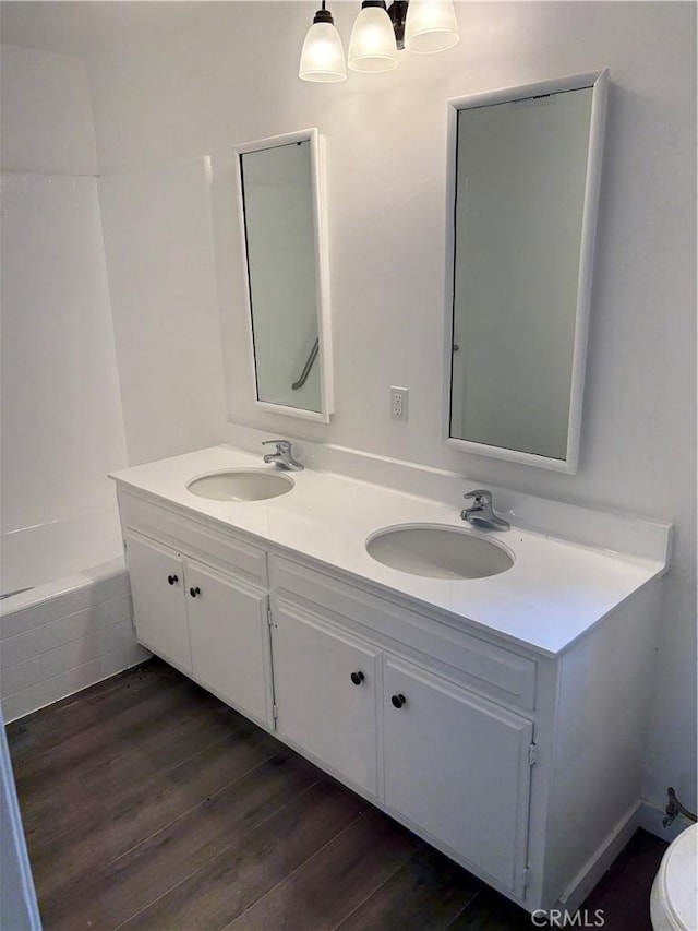 22555 Fern Ann Falls Rd, Chatsworth, CA 91311 - bathroom featuring double vanity, wood finished floors, toilet, and a tub to relax in