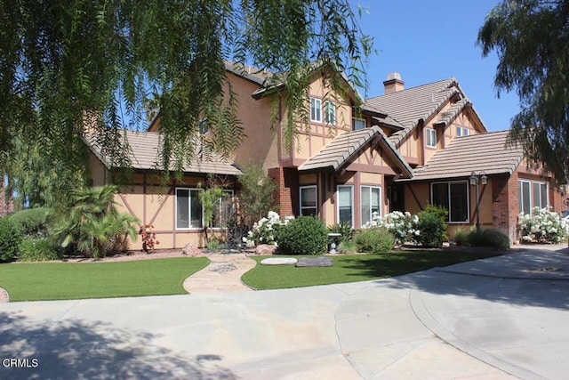 35135 Caprock Rd, Santa Clarita, CA 91390 - english style home with stucco siding, a front lawn, a tile roof, and a chimney