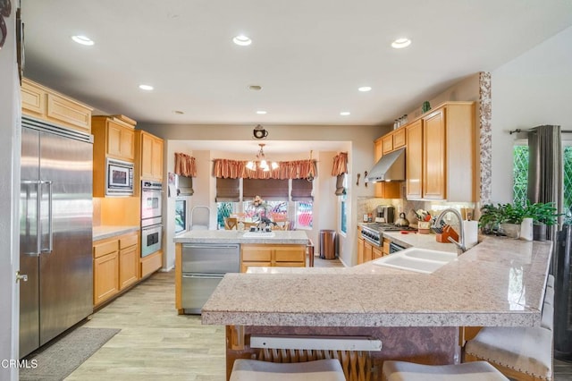 35135 Caprock Rd, Santa Clarita, CA 91390 - kitchen featuring built in appliances, under cabinet range hood, light countertops, a peninsula, and light wood-style floors
