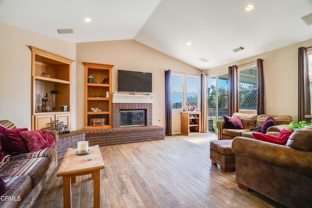 35135 Caprock Rd, Santa Clarita, CA 91390 - living area featuring vaulted ceiling, wood finished floors, a brick fireplace, recessed lighting, and built in shelves
