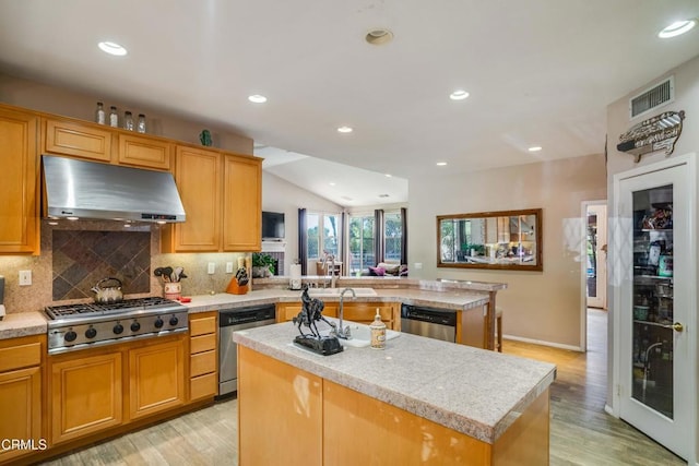 35135 Caprock Rd, Santa Clarita, CA 91390 - kitchen with appliances with stainless steel finishes, ventilation hood, a kitchen island, light countertops, and light wood-type flooring