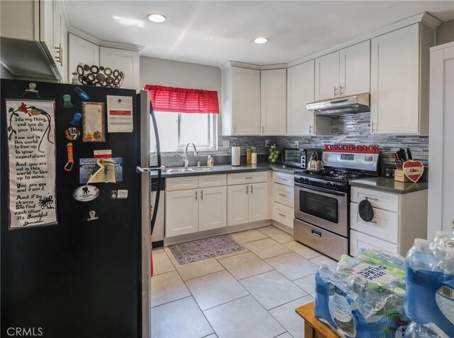 2026 W 94th Pl, Los Angeles, CA 90047 - kitchen with appliances with stainless steel finishes, under cabinet range hood, a sink, backsplash, and dark countertops
