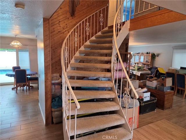 17352 Rob Roy Cir, Huntington Beach, CA 92647 - staircase with wood finished floors, wooden walls, and a textured ceiling