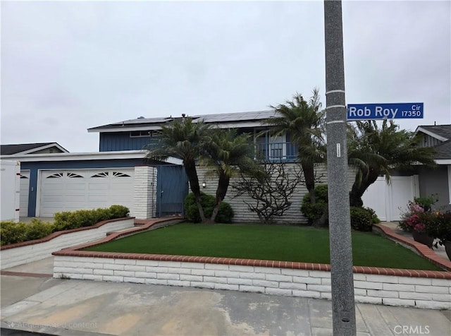 17352 Rob Roy Cir, Huntington Beach, CA 92647 - view of front of house with solar panels, a front yard, and a garage