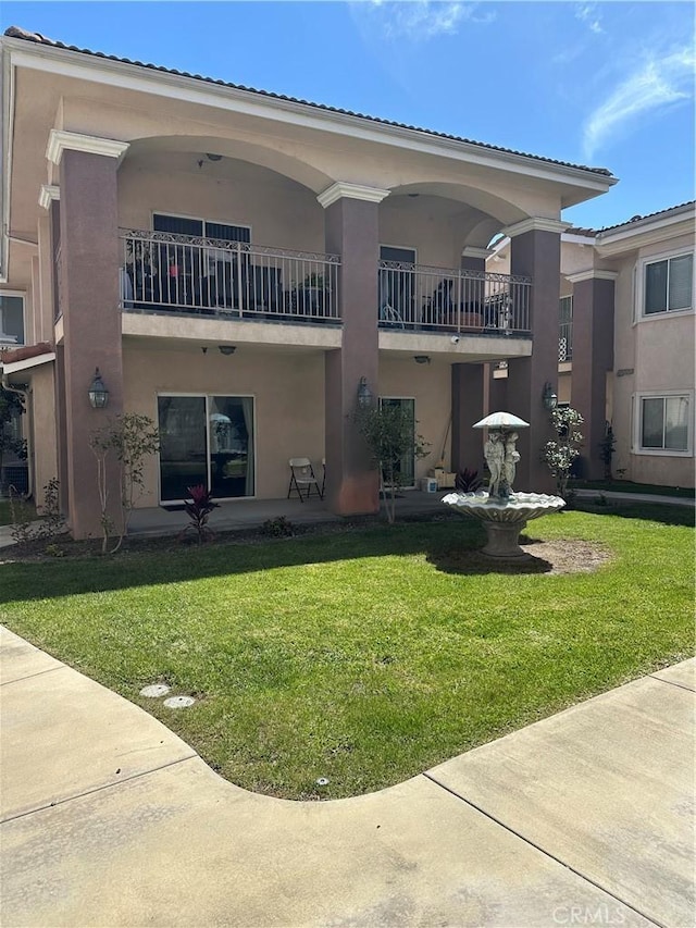 17888 Alburtis Ave Unit B112, Artesia, CA 90701 - rear view of property with stucco siding, a balcony, and a yard