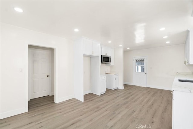 6751 7th Ave, Los Angeles, CA 90043 - unfurnished living room with light wood-style floors, baseboards, recessed lighting, and a sink