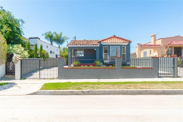 6751 7th Ave, Los Angeles, CA 90043 - mediterranean / spanish home featuring a tile roof, stucco siding, a fenced front yard, and a gate
