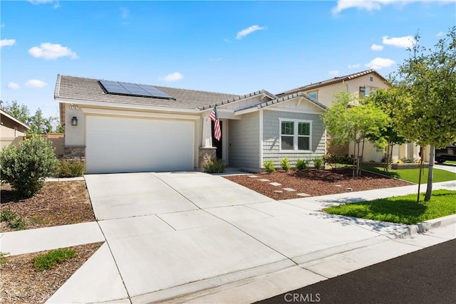 2767 E Murdock Ln, Ontario, CA 91762 - view of front facade featuring an attached garage, roof mounted solar panels, concrete driveway, and stone siding