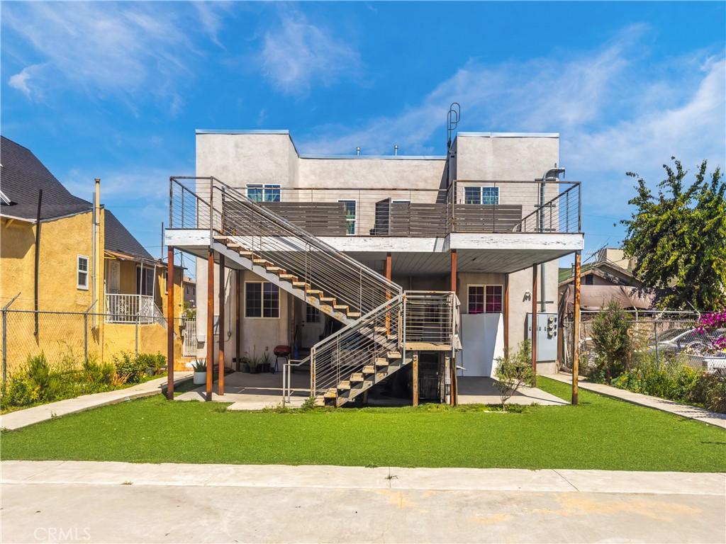 1243 S Kenmore Ave, Los Angeles, CA 90006 - back of property with stucco siding, stairs, and a patio area
