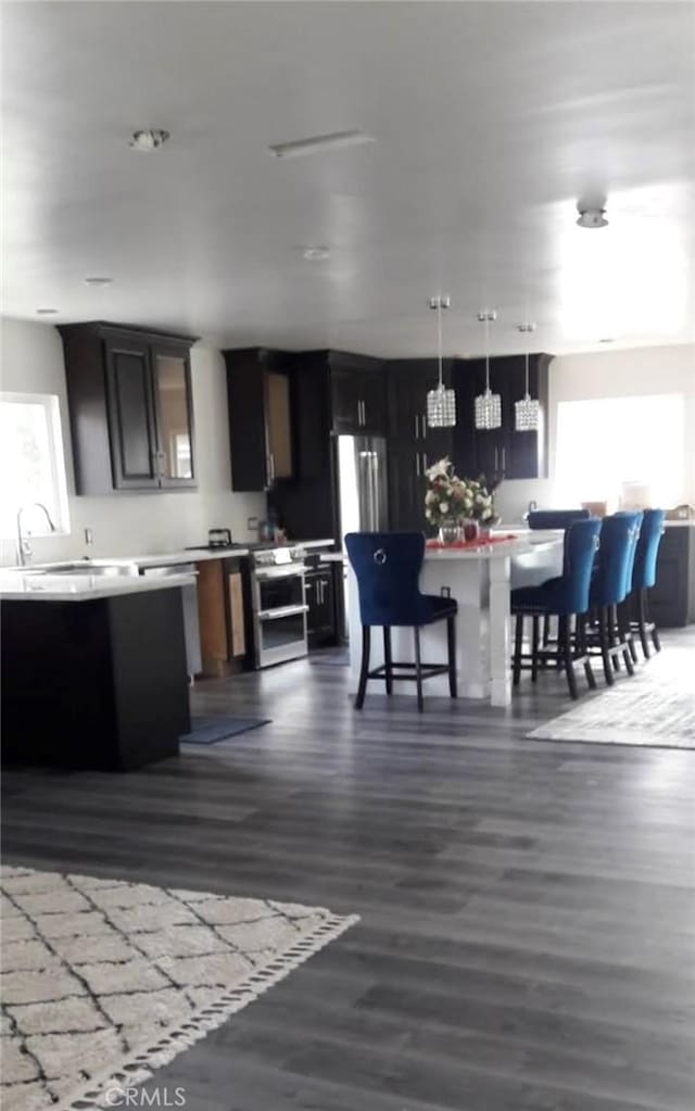 11022 Maple St, Whittier, CA 90601 - kitchen featuring light countertops, dark wood finished floors, a center island, pendant lighting, and fridge