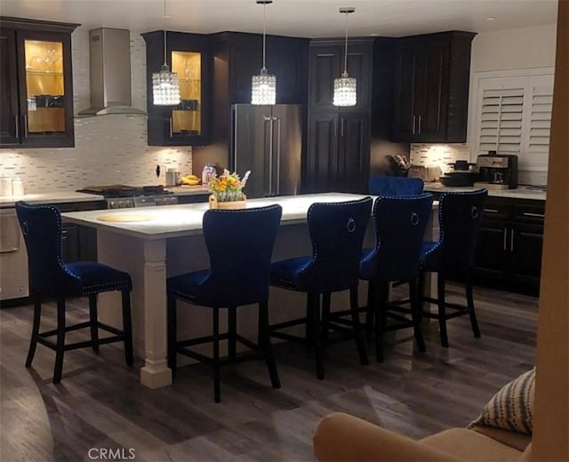 11022 Maple St, Whittier, CA 90601 - kitchen with wall chimney exhaust hood, high end fridge, a breakfast bar, and backsplash